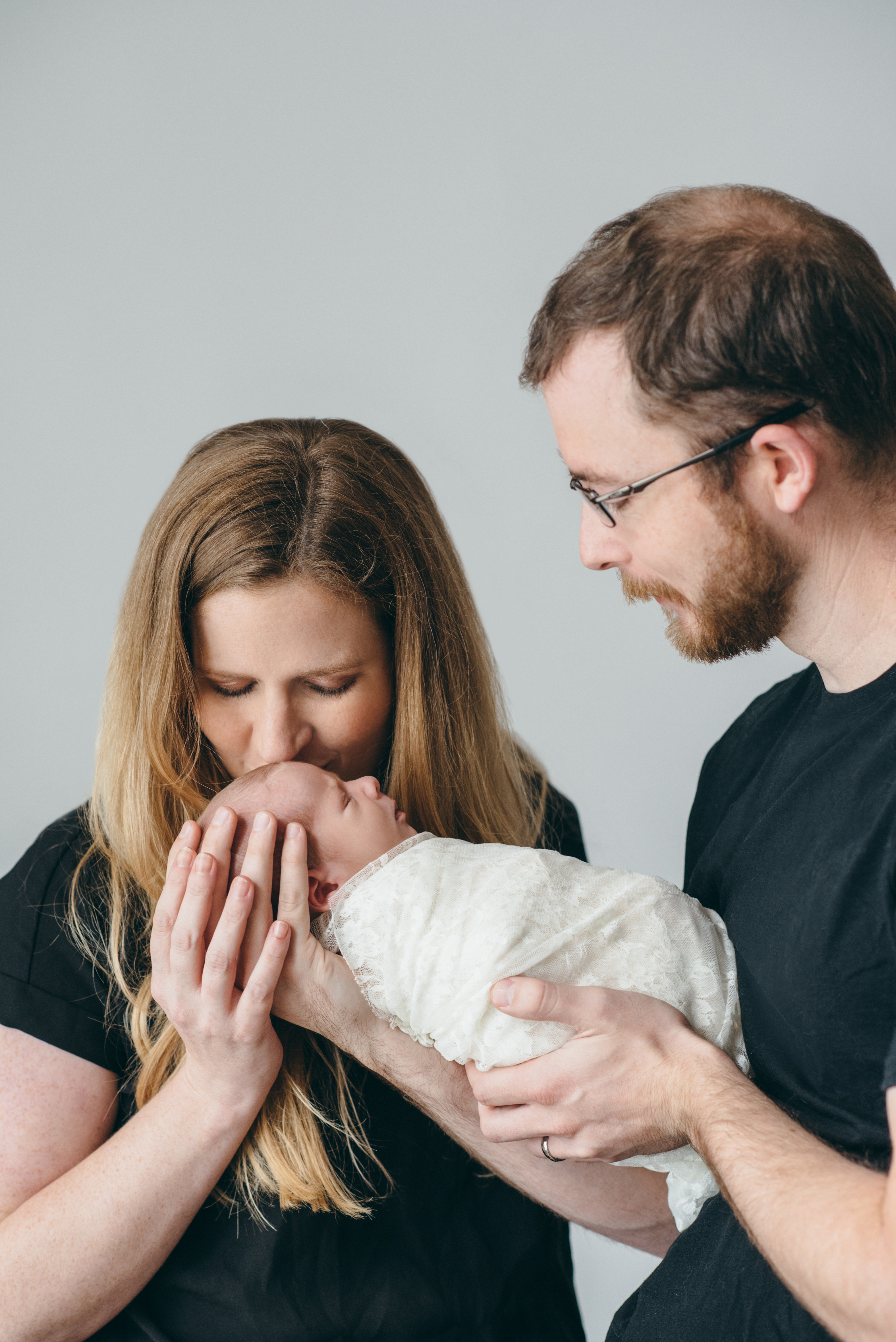 mother kissing newborn daughter's head