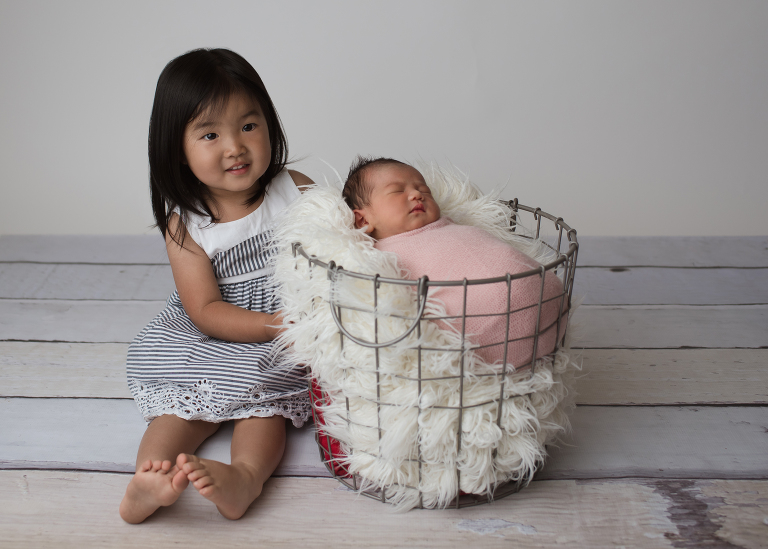 newborn baby girl in basket, big sister