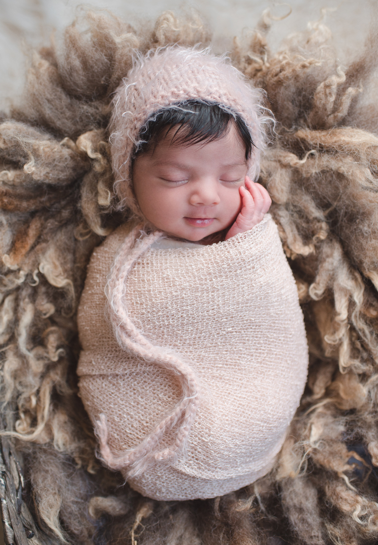 swaddled baby girl in neutral colors