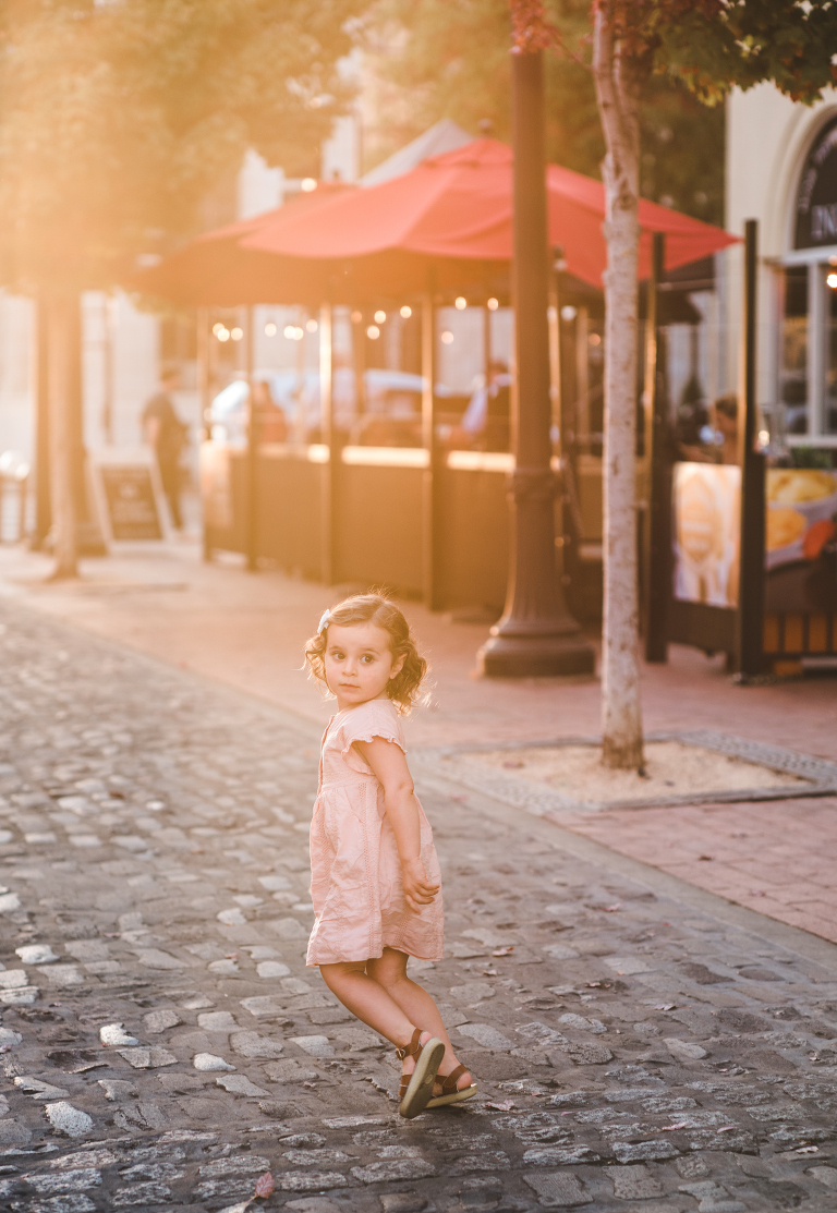 downtown Petaluma, cobblestone street, brick sidewalk, little girl, Saltwater sandals, peach dress, curly hair